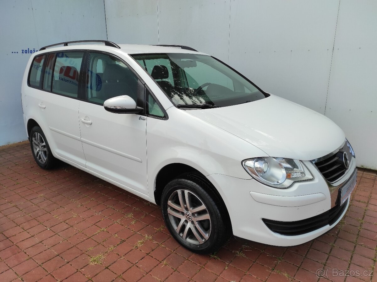 Bílý sedmimístný Volkswagen Touran k apartmánu